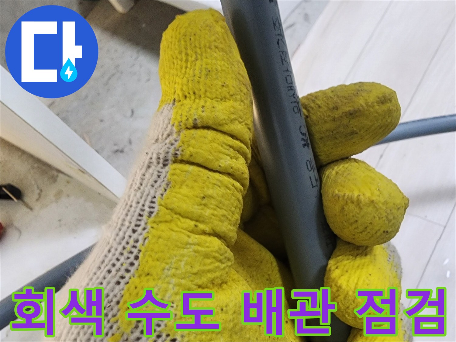 작업자가-직접-회색-배관의-연결부를-살피는-장면