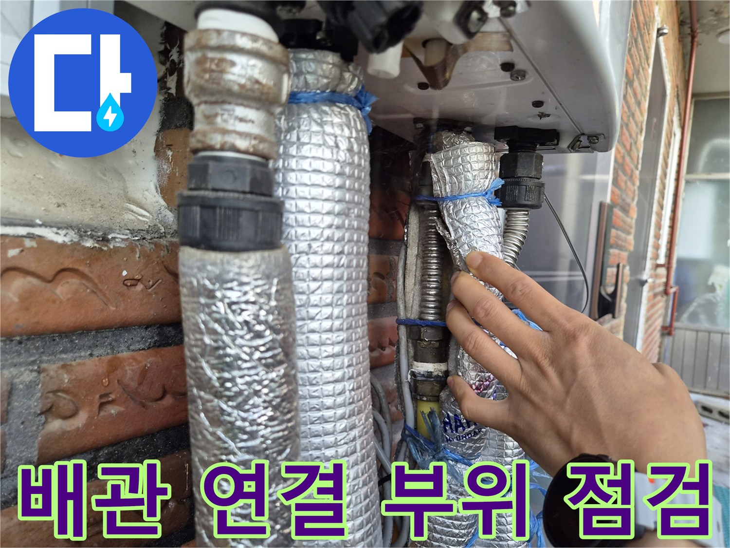 보일러 하단 연결 부속과 단열재가 씌워진 배관의 모습