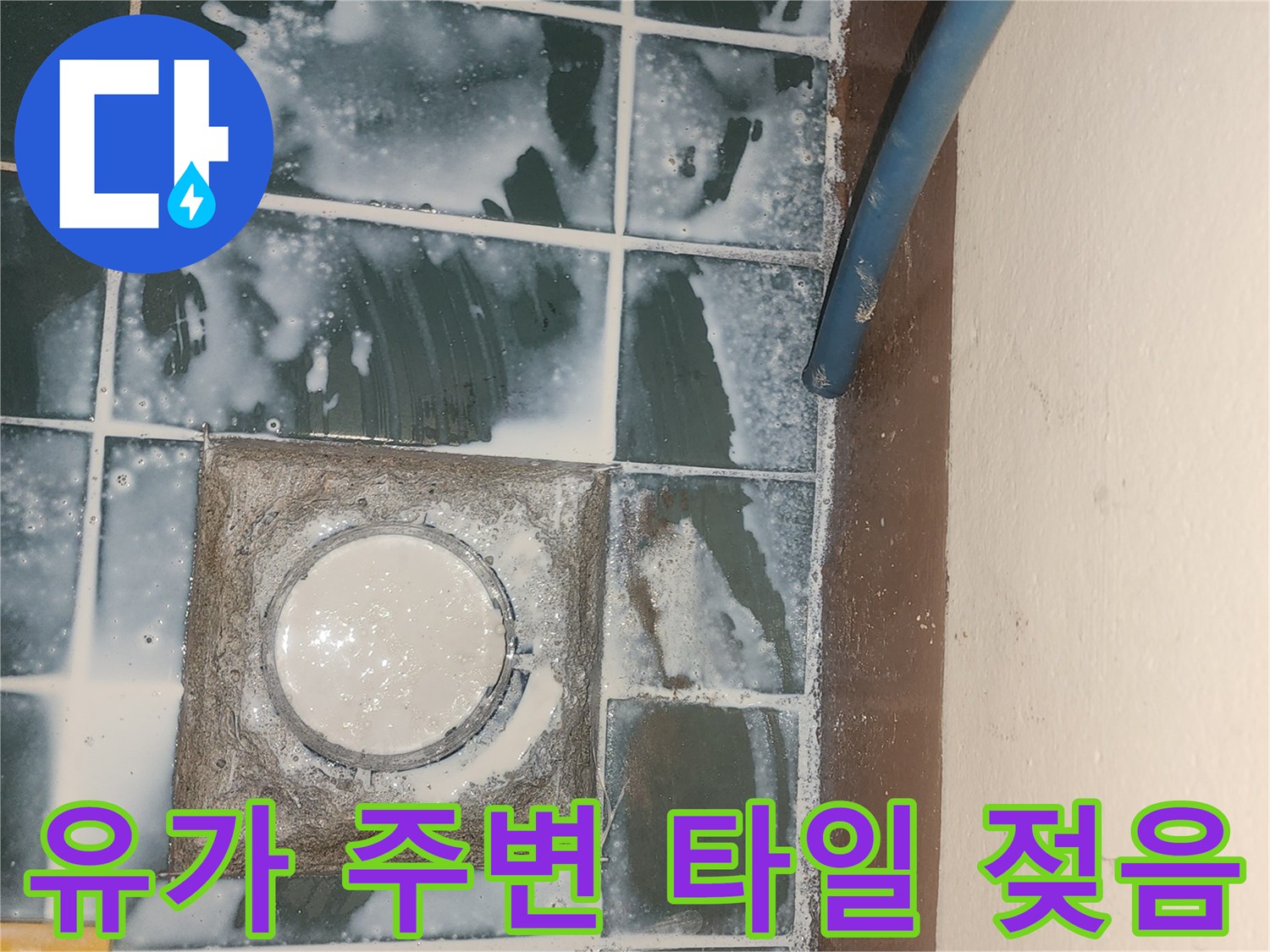물기가 번져 있는-배수구 주변 타일 모습
