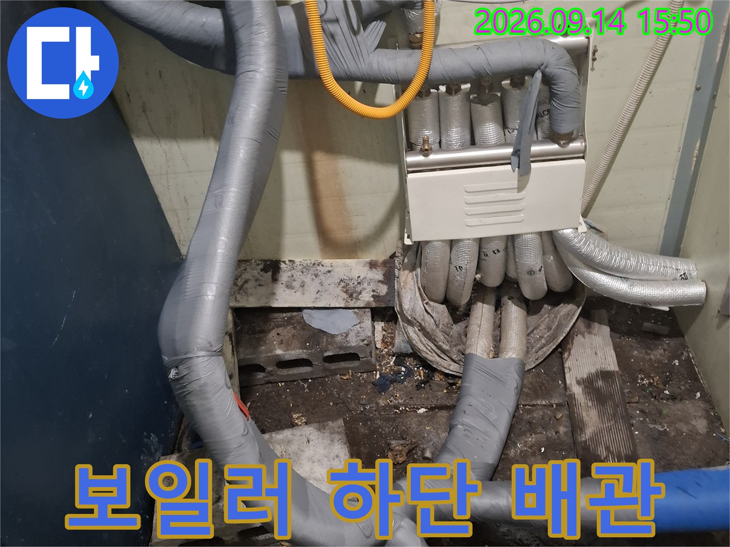 회색 보온재가 씌워진 보일러 연결 배관의 상세 촬영본입니다.