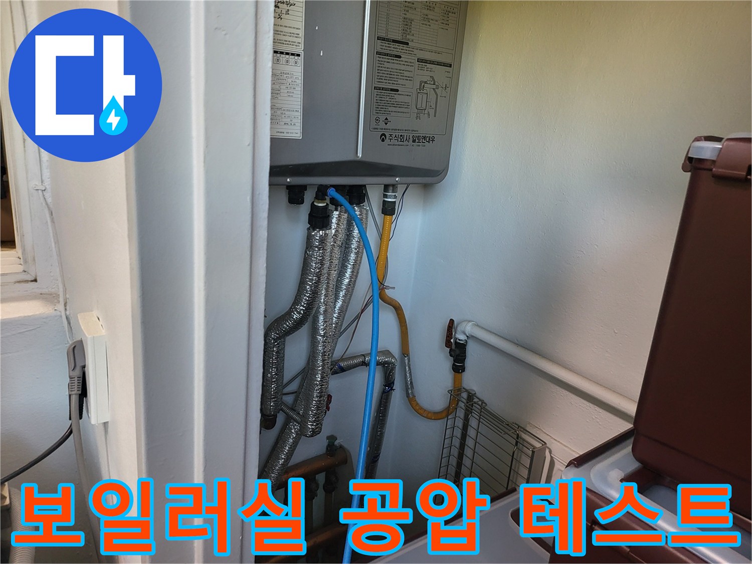 보일러 하부 배관에 연결된 파란색 압력 측정 호스