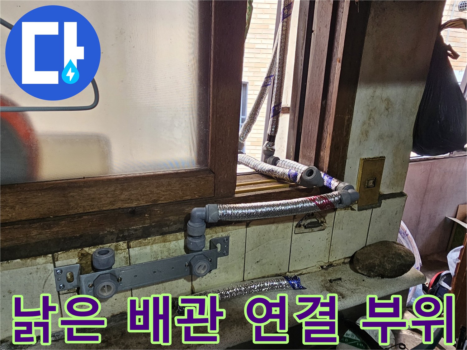 연결 부속과 은색 자재가 노후된 외부 배관의 모습입니다.